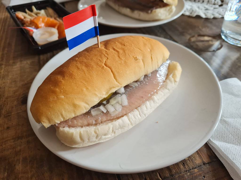 Hollandse Nieuwe в хлебче с накълцан лук и кисела краставичка. (Снимка: Петя Аргирова)